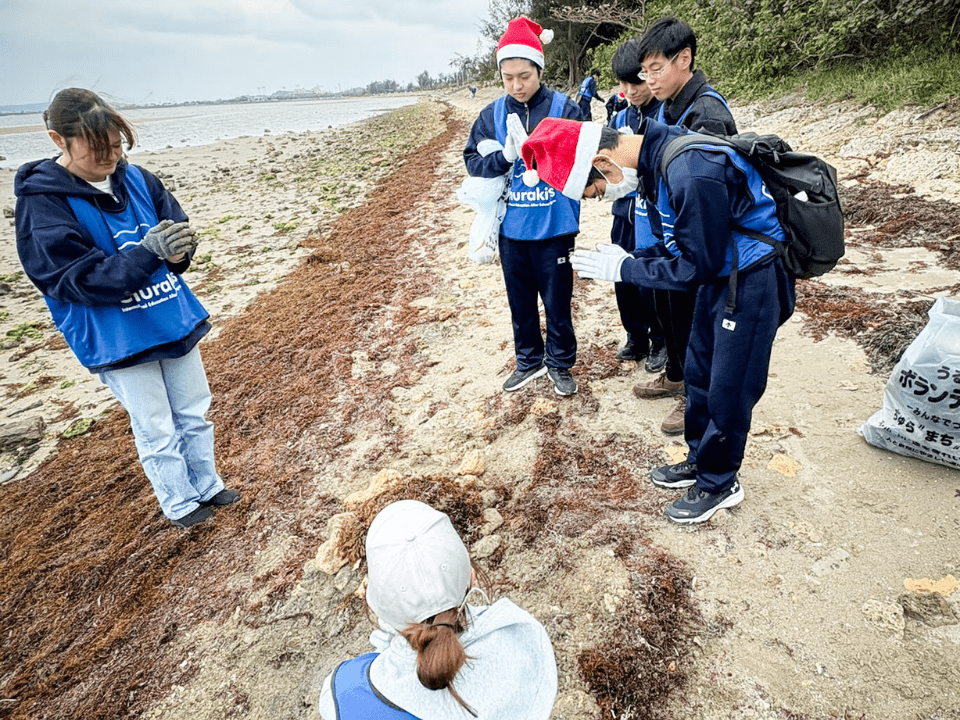 砂浜で見つけたココナッツなどの漂着物を観察する子どもたち