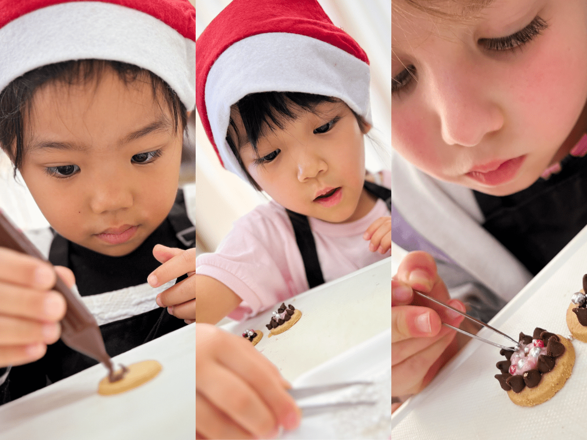 真ける表情でクッキーにアイシングのデコレーションをする子どもたち