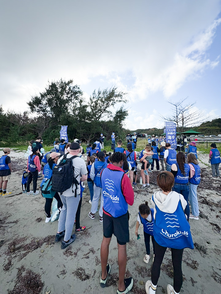 ブルーのChurakidsベストを着てビーチに集まる参加者たち