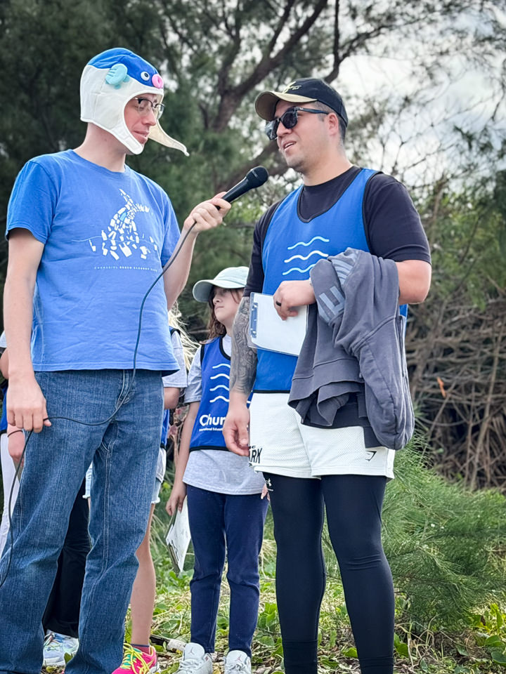 マイクを持って発表する子どもとサポートするスタッフ