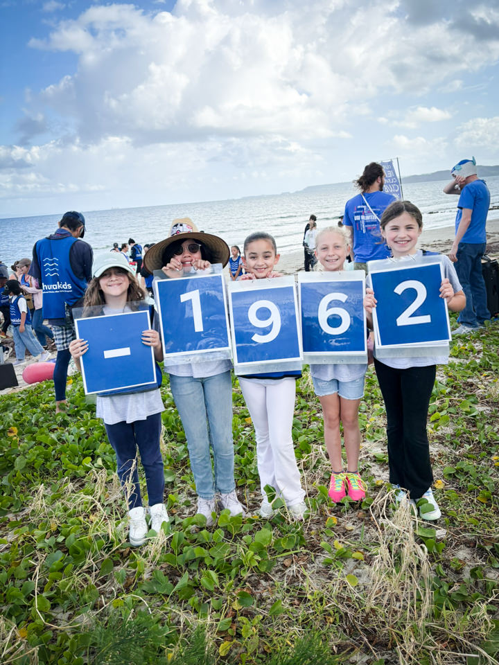 累計回収袋数1962を子どもたちがプラカードで示している様子